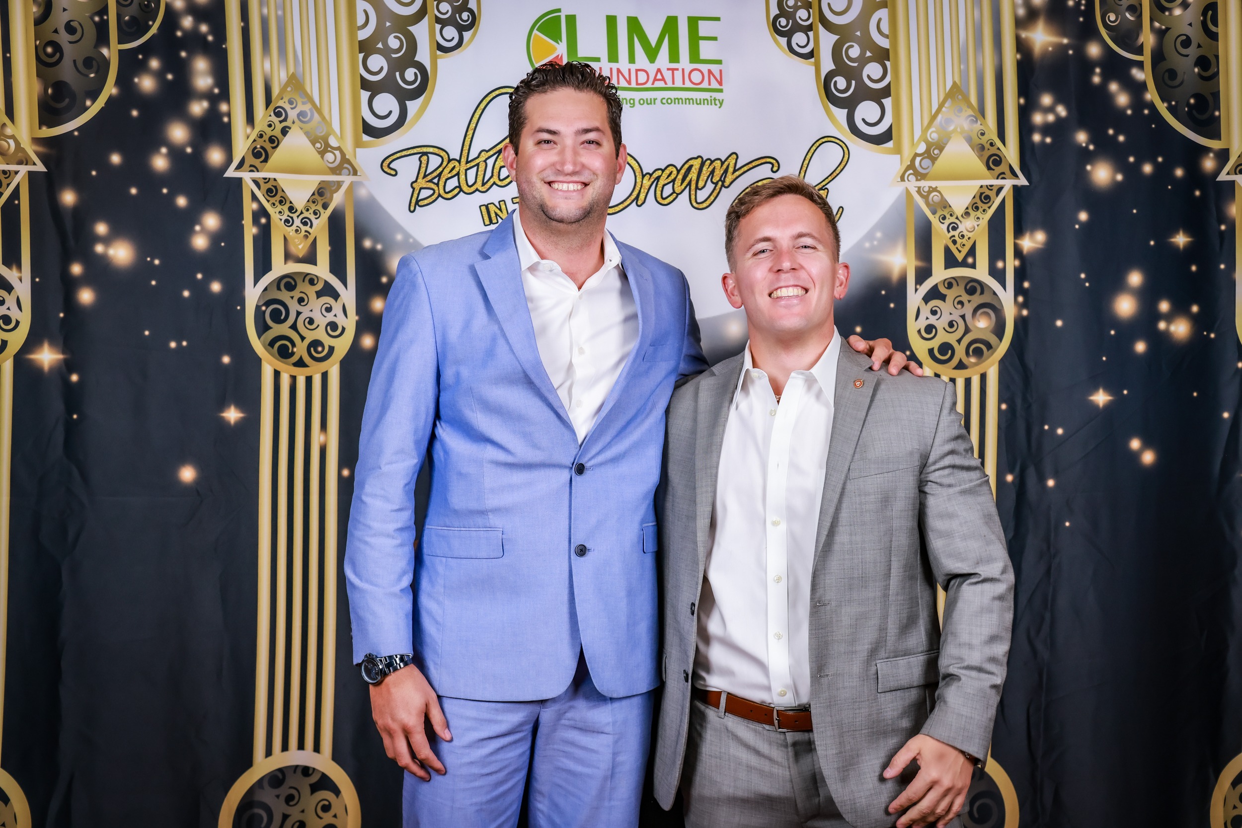 Two men in suits posing for a photo in front of a backdrop at The LIME Foundation of Santa Rosa.