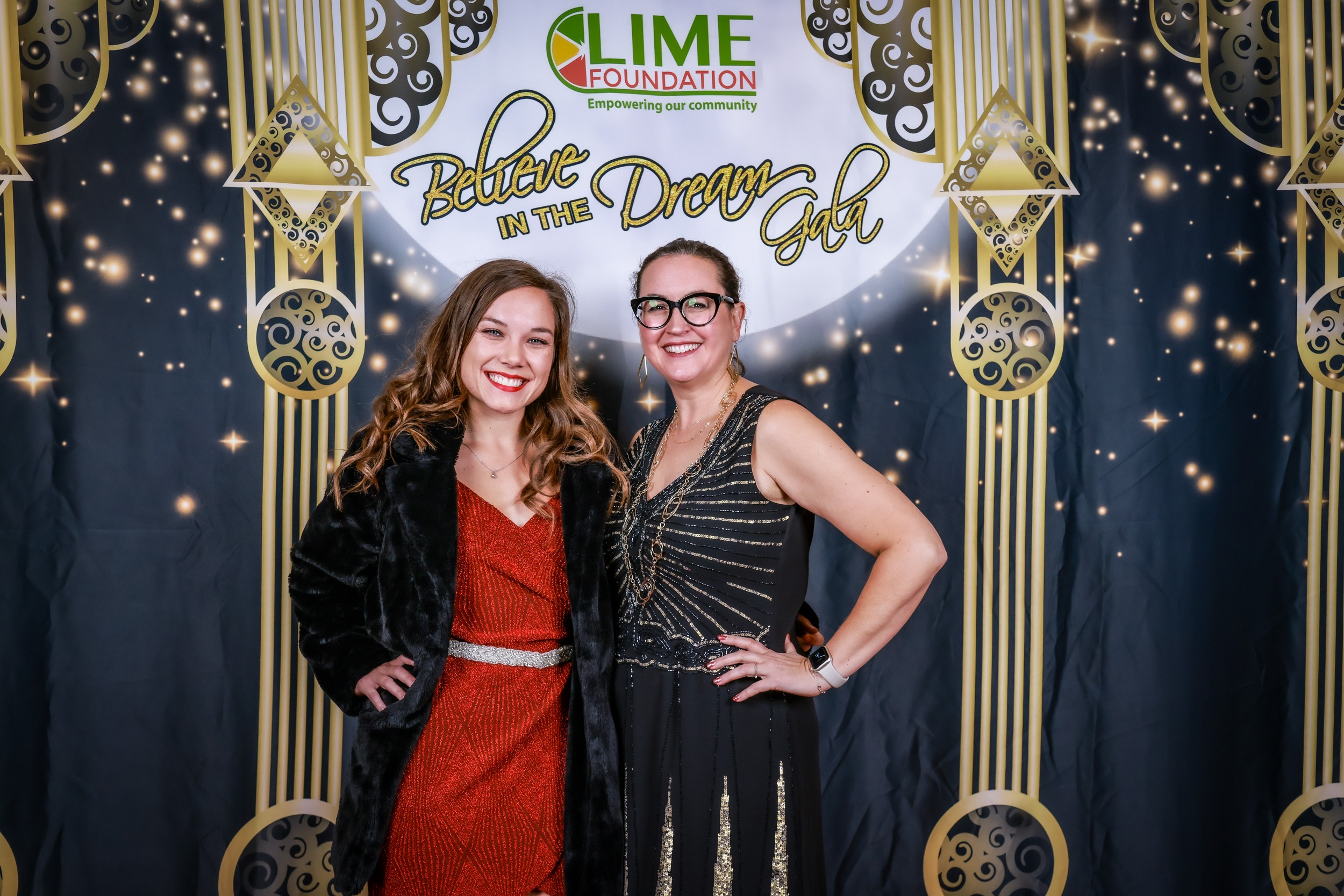 Two women posing for a photo in front of a gilded backdrop at The LIME Foundation in Santa Rosa.