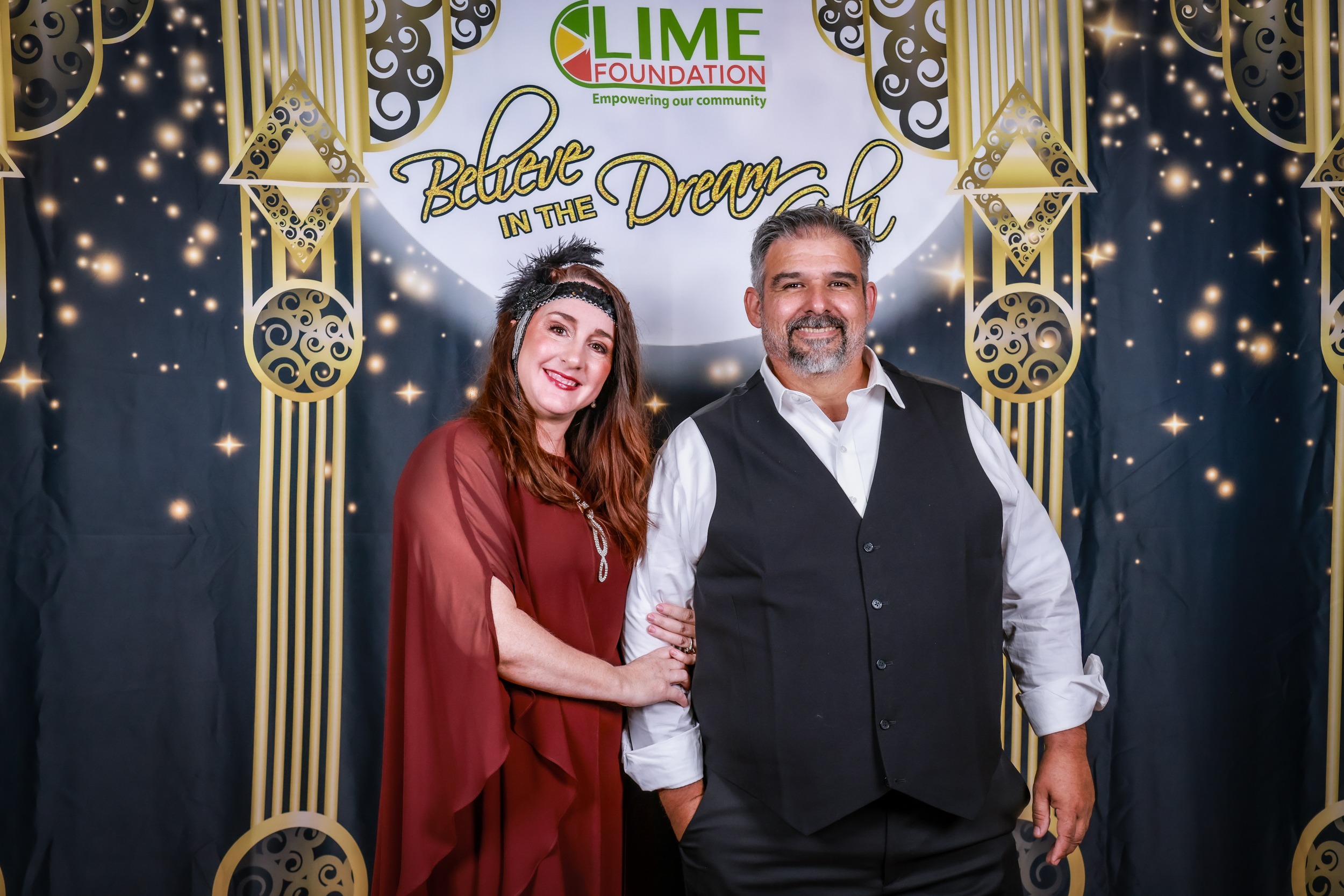 A man and woman posing in front of a photo booth at The LIME Foundation of Santa Rosa.