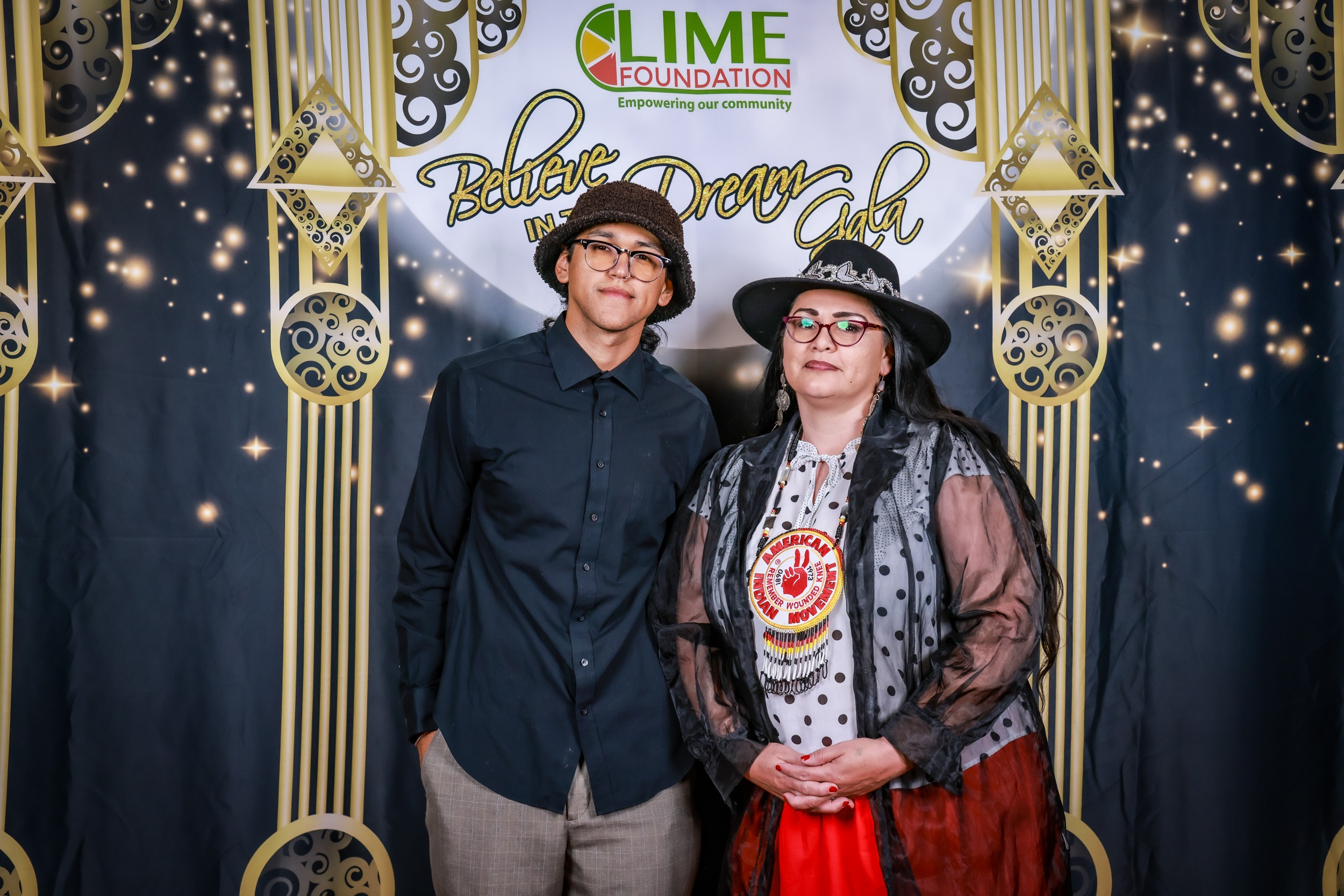 A man and woman posing in front of a photo booth at The LIME Foundation of Santa Rosa.