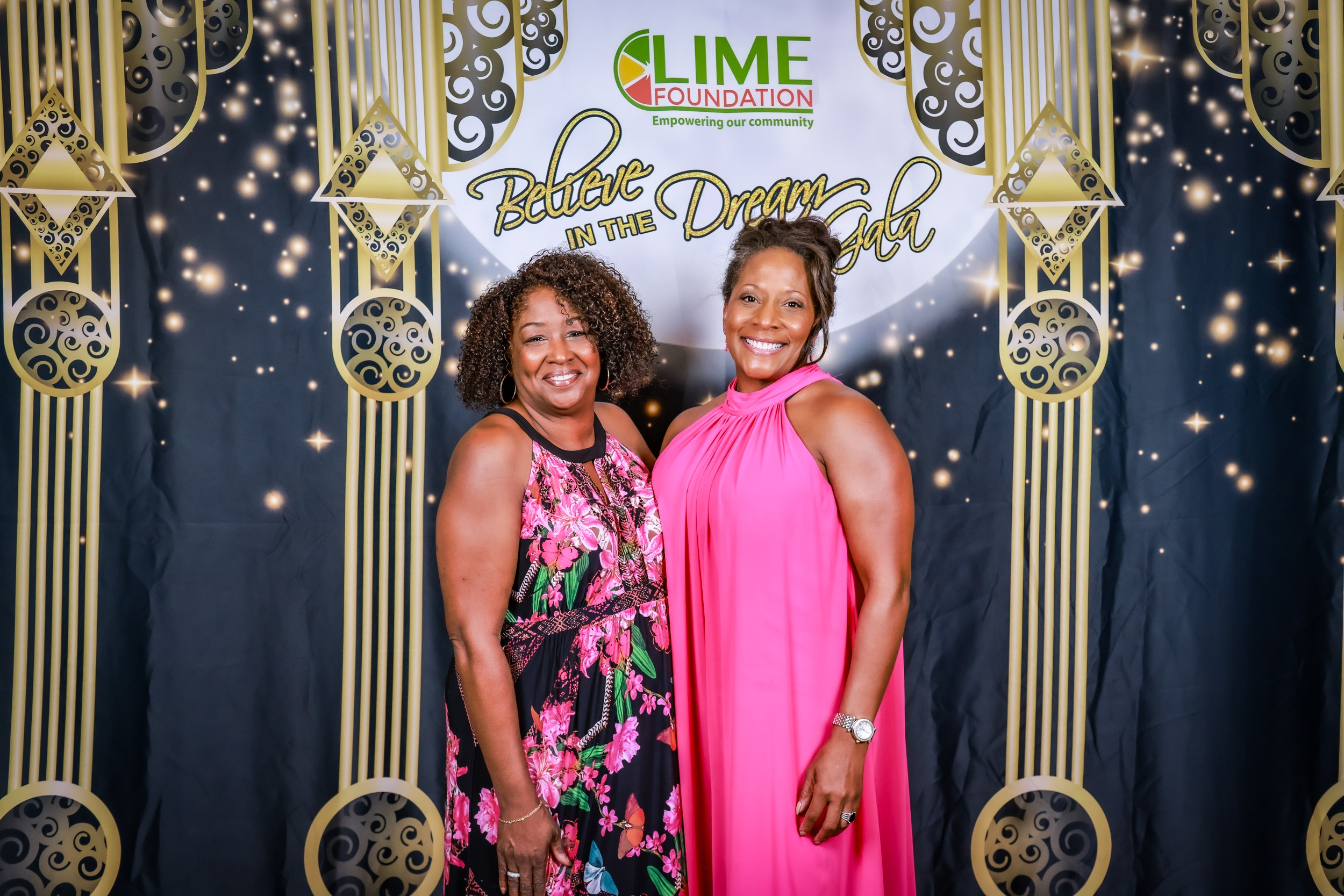 Two women posing for a photo in front of a backdrop at The LIME Foundation of Santa Rosa.