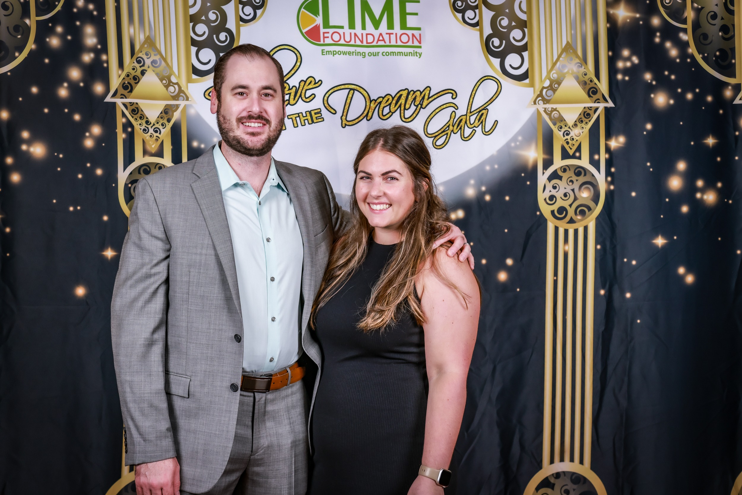 A man and woman posing for a photo in front of a backdrop at The LIME Foundation of Santa Rosa.