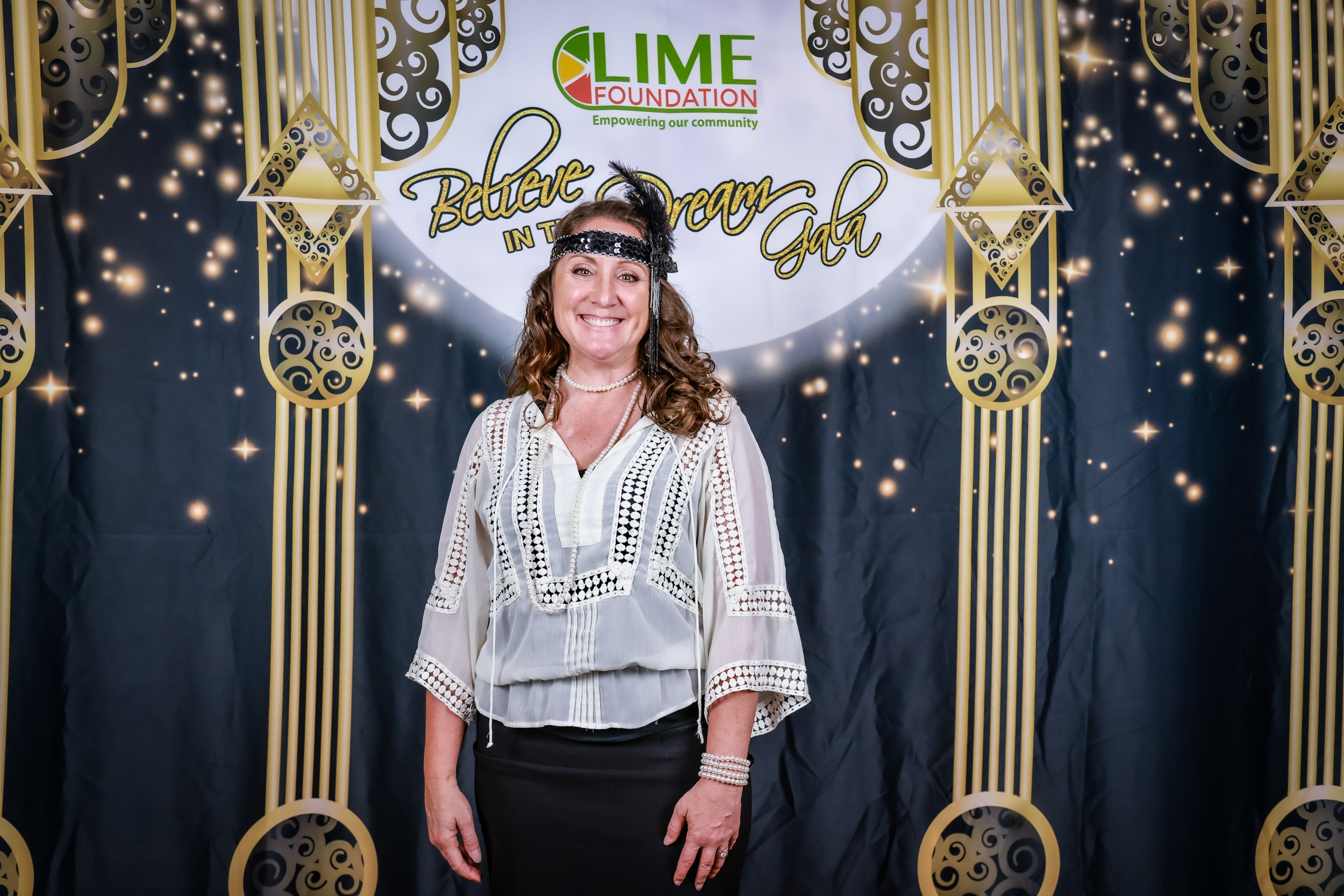 A woman posing for a photo in front of The LIME Foundation backdrop.