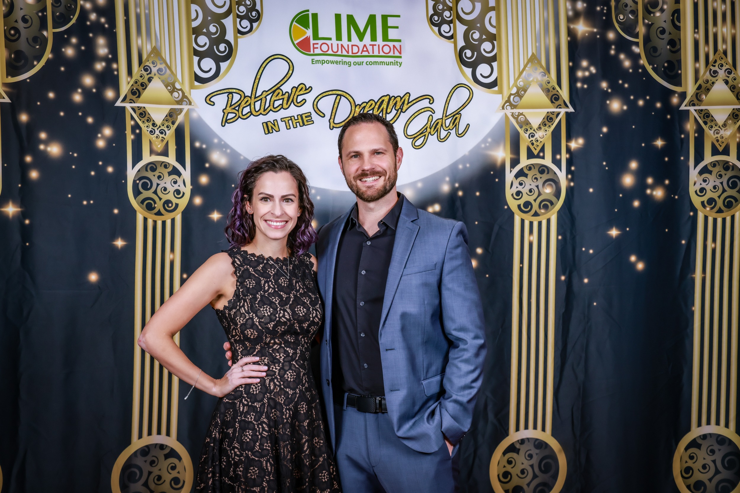 Two individuals posing for a photo in front of a gilded backdrop at The LIME Foundation of Santa Rosa.