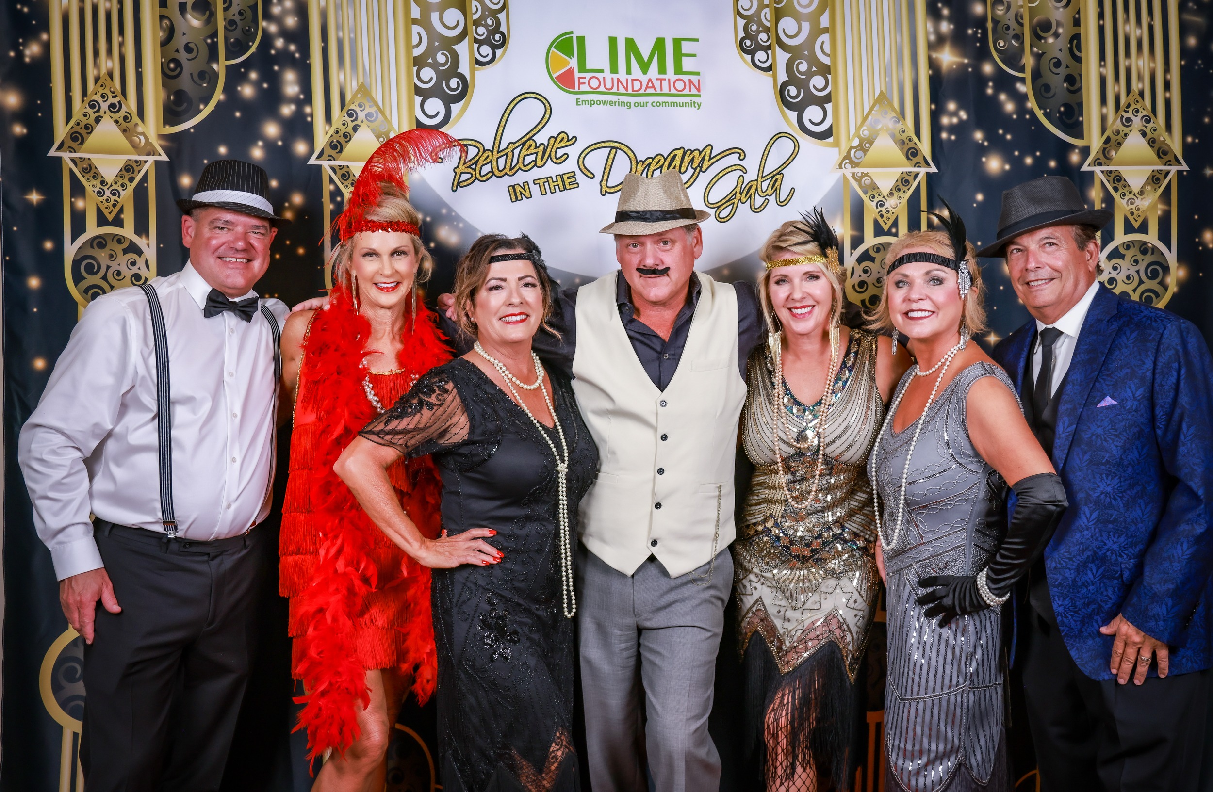 A group of people posing for a photo at a Gatsby themed party hosted by The LIME Foundation of Santa Rosa.