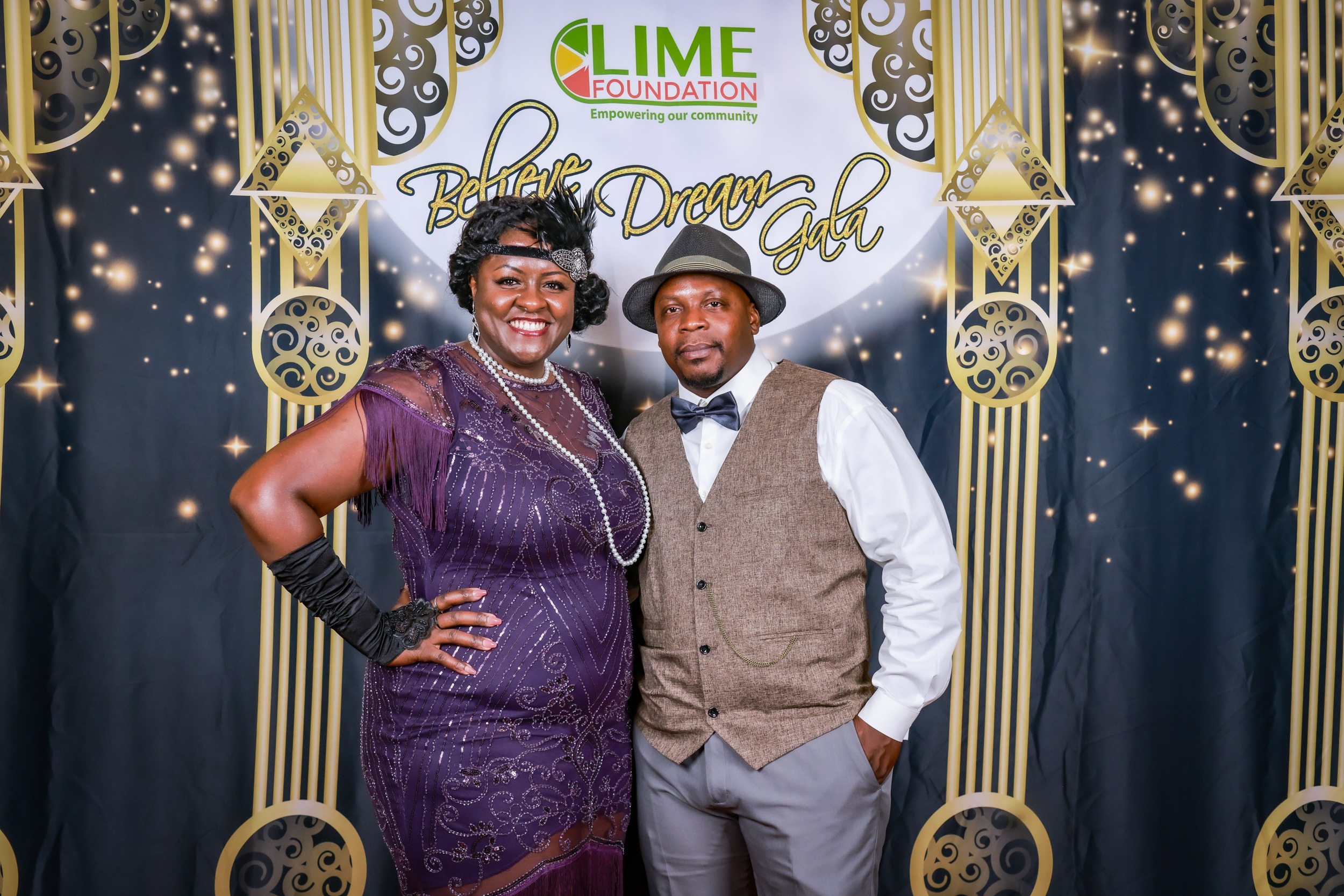 A couple posing for a photo at a 1920's themed party hosted by The LIME Foundation of Santa Rosa.